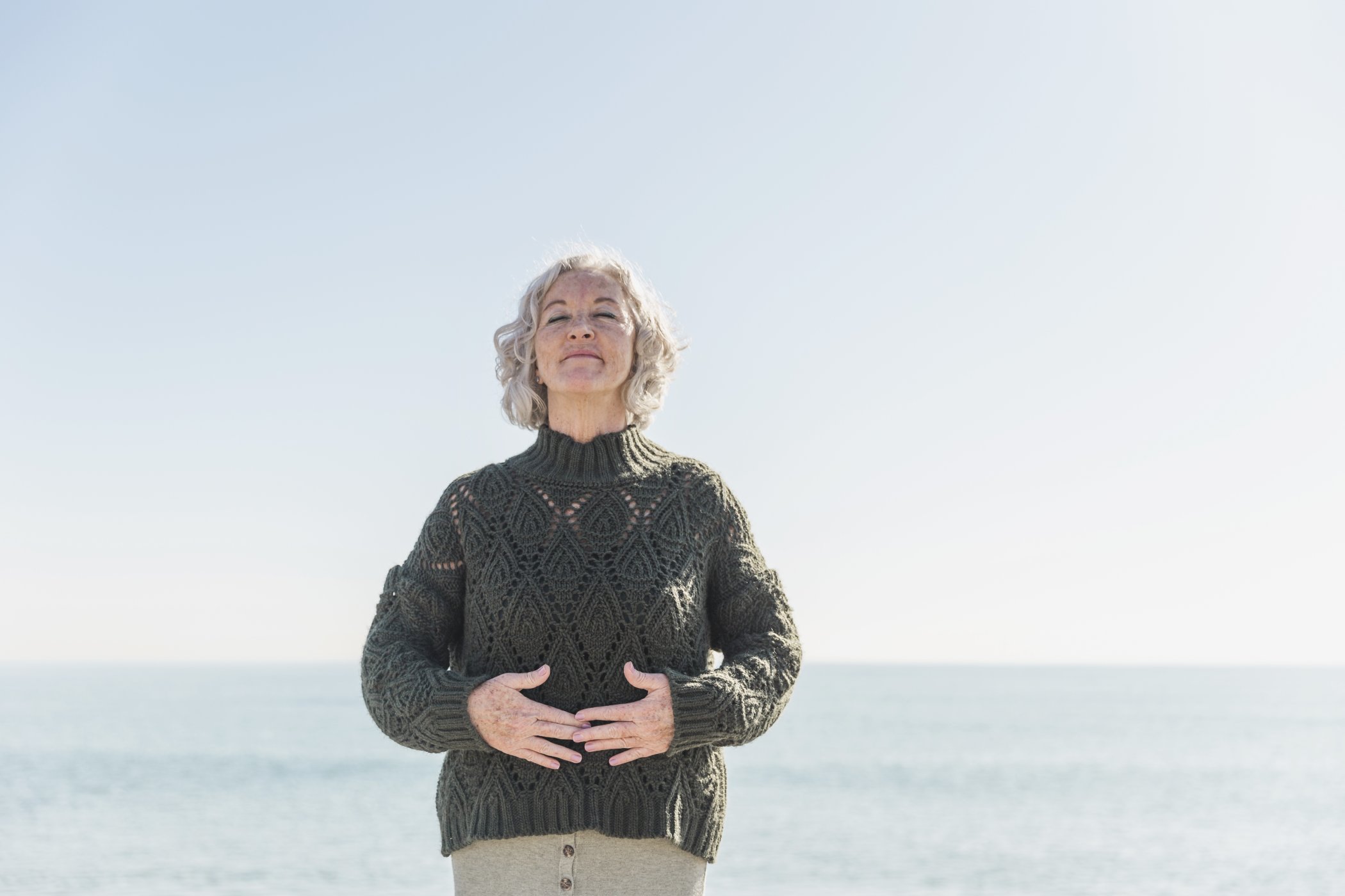 front-view-old-woman-with-closed-eyes-beach